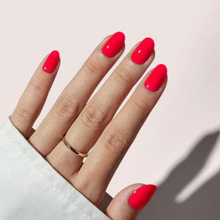 Hand with bright red nails on a light background
