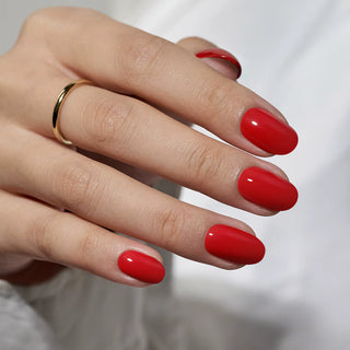 Hand with red nail polish on a blurred background