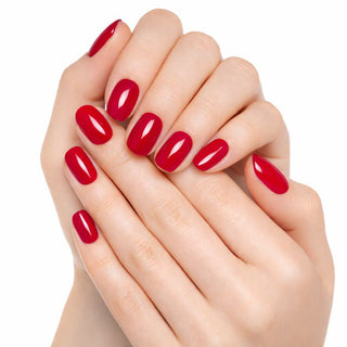 Close-up of hands with red nail polish on a white background