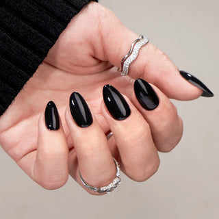 Hand with black nail polish on a neutral background