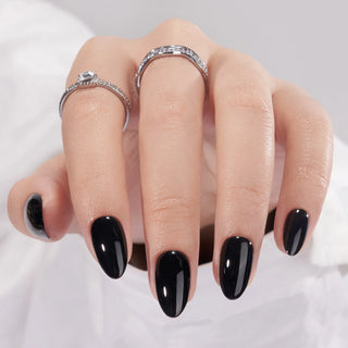 Hand with black nail polish and silver rings on a white background