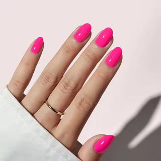 Hand with bright pink nails on a light background