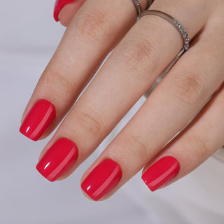 Hand with red nail polish on a neutral background