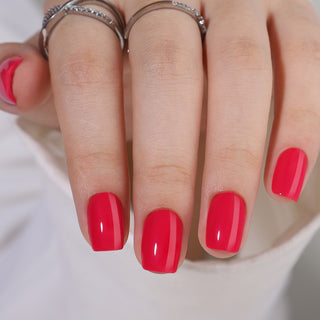 Close-up of a hand with red nail polish on a plain background