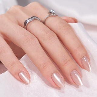 Hand with polished nails and silver rings on a soft fabric background