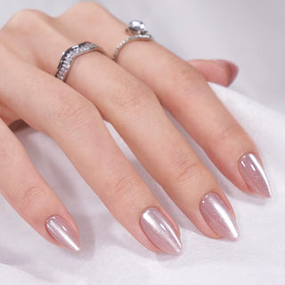 Hand with pink glittery nails and silver rings on a white background