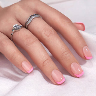 Hand with pink nail polish and silver ring on a white background