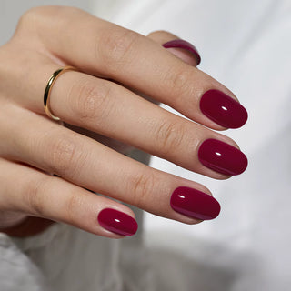 Hand with burgundy nail polish on a blurred background