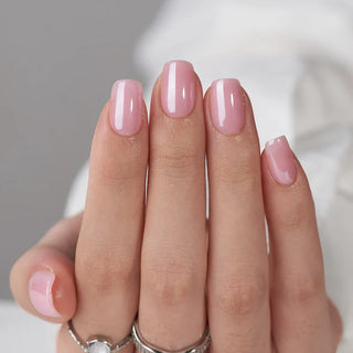Hand with pink nail polish on a neutral background