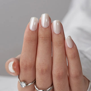 Close-up of a hand with beige nail polish on a neutral background